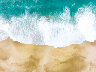 Aerial overhead photograph of a beach. Golden sand and turquoise water. The ocean water merges with the sand of the beach.  © JMGarcestock
