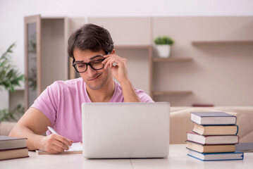 Young male student preparing for exams at home