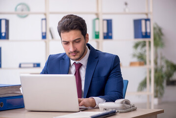 Young male employee and too much work in the office