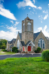 Fototapeta na wymiar Exterior of Modern Church with red doors. Summer day, blue sky.