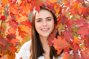 Portrait of young woman with autumn leafs. Romantic girl dream, hold fall maple leaves. Autumnal season.