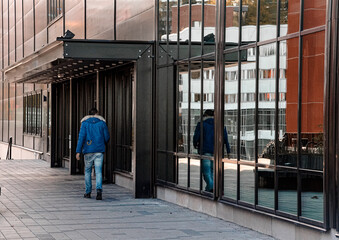 Rare view of a man walking in front of a building 