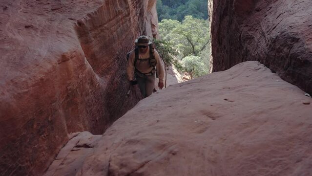 A man exploring a slot canyon in the desert