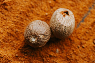 Nutmeg whole and ground.condiments and spices background. Nutmeg fruits in powder.Nutmeg in a cut and nutmeg powder