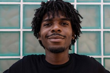 Happy afro boy with curly hair. Turquoise background