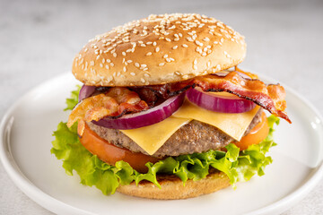 Delicious hamburger with meat, cheese, bacon and salad.
