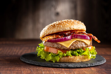 Delicious hamburger with meat, cheese, bacon and salad.