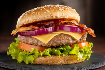 Delicious hamburger with meat, cheese, bacon and salad.