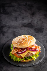 Delicious hamburger with meat, cheese, bacon and salad.