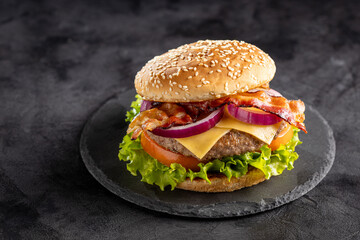 Delicious hamburger with meat, cheese, bacon and salad.