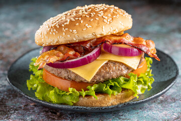 Delicious hamburger with meat, cheese, bacon and salad.