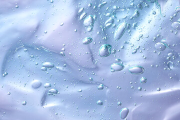 Transparent cleansing gel on violet background, top view. Cosmetic product