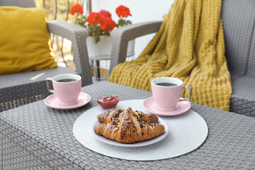 Outdoor breakfast with tea and croissants on white table on terrace