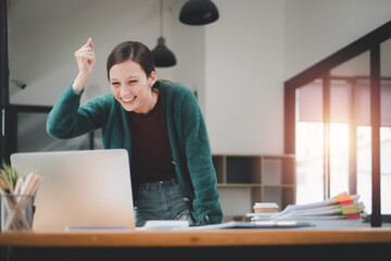 Businesswoman happy and cheerful for successful on project via laptop in office space.