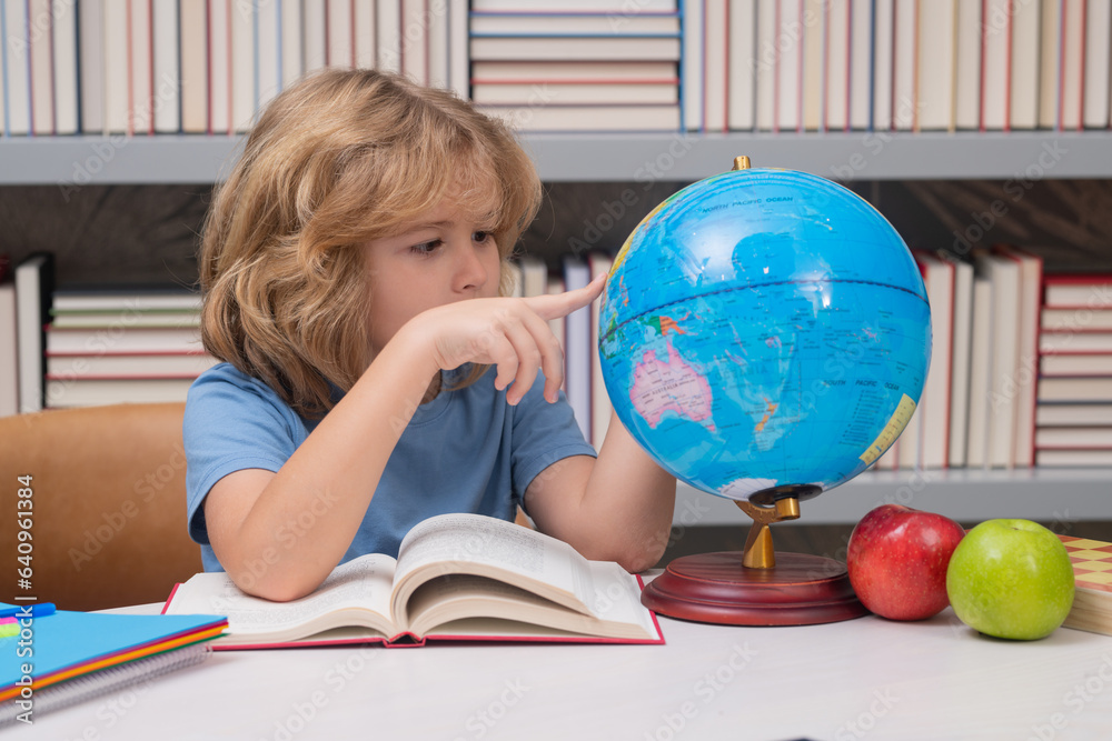 Poster pupil looking at globe in library at the elementary school. nerd school kid. clever child from eleme