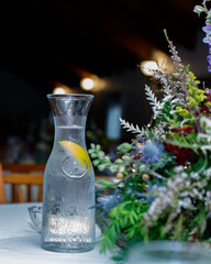still life water jug with lemon event table setting, green.