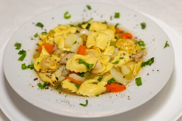 Italian tortellini (capeletti, agnolini) soup with chicken and vegetables, special soup for cold nights