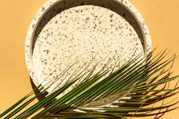 White empty tray for products with palm leaves and shadows on yellow background. Mock up. Close up. Backdrop for advertising.