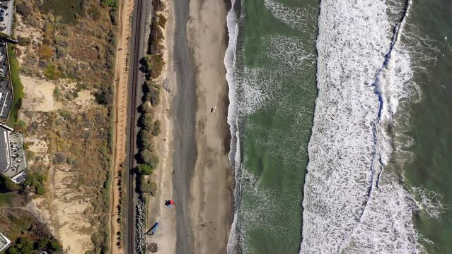 4K drone aerial tracking and stablishing shot of a beach with a pier in California