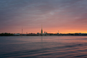 Naklejka premium View of the Peter and Paul Fortress and the Neva River against a pink dawn sky with clouds on a sunny spring morning, St. Petersburg, Russia