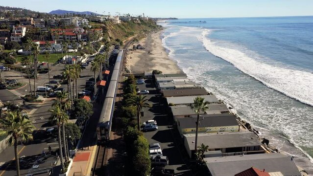 4K drone aerial tracking and stablishing shot of a beach with a pier in California