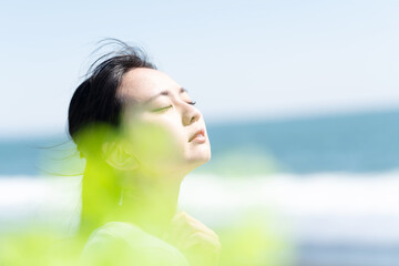 海岸で日差しを浴びる女性