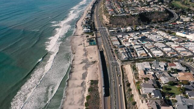 4K drone aerial tracking and stablishing shot of a beach with a pier in California