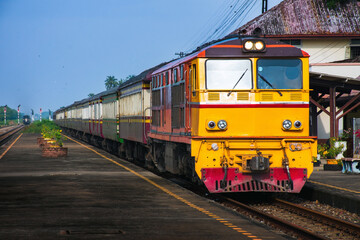 Passenger train by diesel locomotive at the railway station. (Building is public).