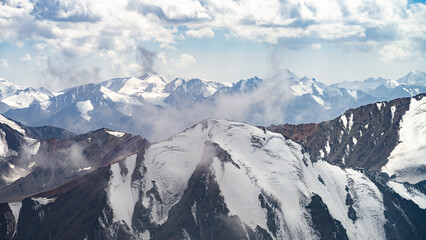 Fototapeta na wymiar beautiful snowy mountain peaks in the clouds. highlands