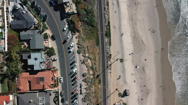 4K drone aerial tracking and stablishing shot of a beach with a pier in California