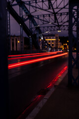 Defocused Lights of cars at night in Krakow bridge. Street line lights. Night highway city. Long exposure photograph night road. Colored bands of red light trails on the road. Background wallpaper