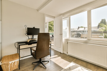 a home office with a desk and chair in front of a large window looking out onto the street below it