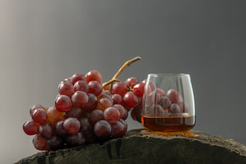 Bunch of purple grapes and glass of whiskey, black background