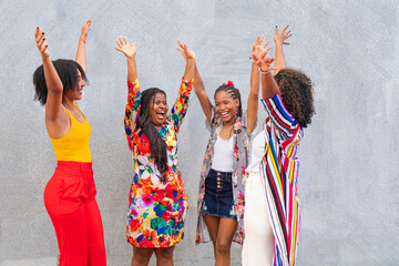 Group of friends with their arms up on the street. Happiness and friendship