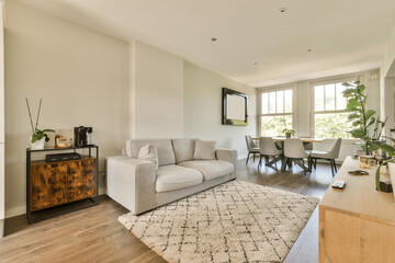 a living room with white walls and hardwood flooring in the center of the room, there is an area for furniture to sit