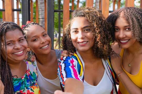 Group of friends capturing joyous moments on a sunny day outdoors