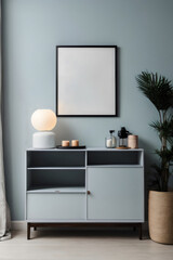 a blank black portrait frame hangs on the wall above a pastel gray wooden sideboard