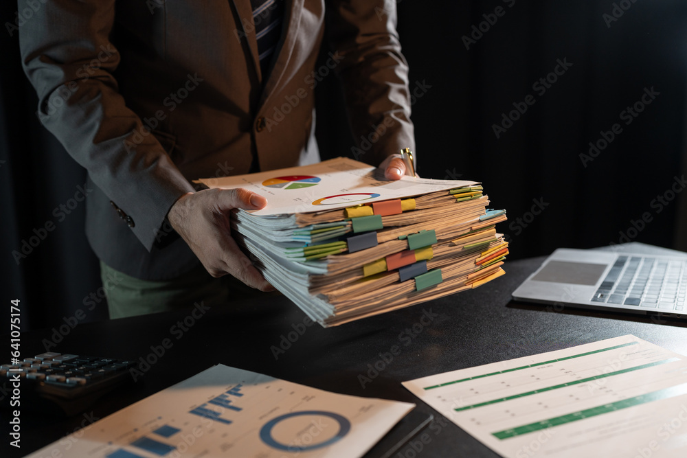 Wall mural asian businessman working on paperwork on desk gather documents from meeting minutes. documents fina