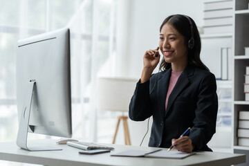 Asia call center with headset and microphone working on laptop Female entrepreneurs serving customers, business information, inquiries Support call center representatives help customers.
