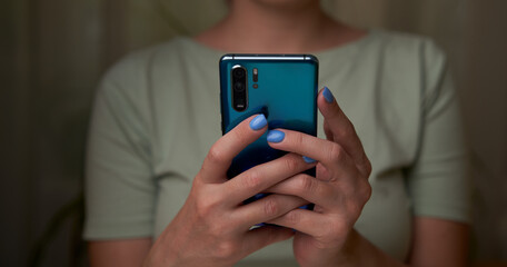 Woman is using smartphone, writing a message, browsing social networks.
