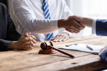 Businessman Shaking Hands In Front Of Mallet, justice and law concept. male lawyer working in...