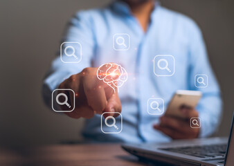 Businessman hand pointing to brain with modern technology search The concept of speed in finding and accessing information.