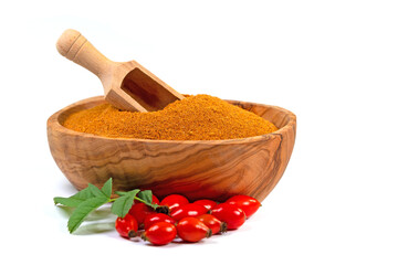 Hagebuttenpulver in einer Holzschale vor weißem Hintergrund