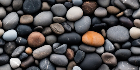 Fototapeta na wymiar River rocks or stones in a seamless tiled pattern. Naturally polished and rounded river pebbles create a repeating background texture.