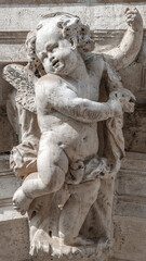 Venice, Italy - Portrait with a ancient wall decoration sculpture of a beautiful angel as a child with wings in historical downtown of Venice