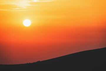 Beautiful sunset in a mountainous area. The sun sets on the mountain. 
