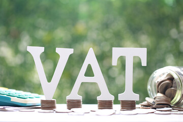 Tax word and coins money on natural green background,Business investment and Property tax concept