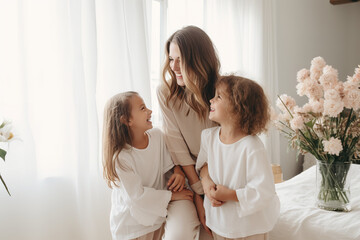 minimalis photo of little children congratulating and hug her mother at home, minimalist and white home decor