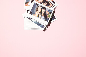 Collage of polaroids on pink background of 2 multiracial women having fun