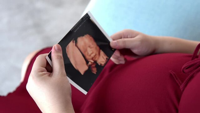 Pregnant woman holding baby Photos
